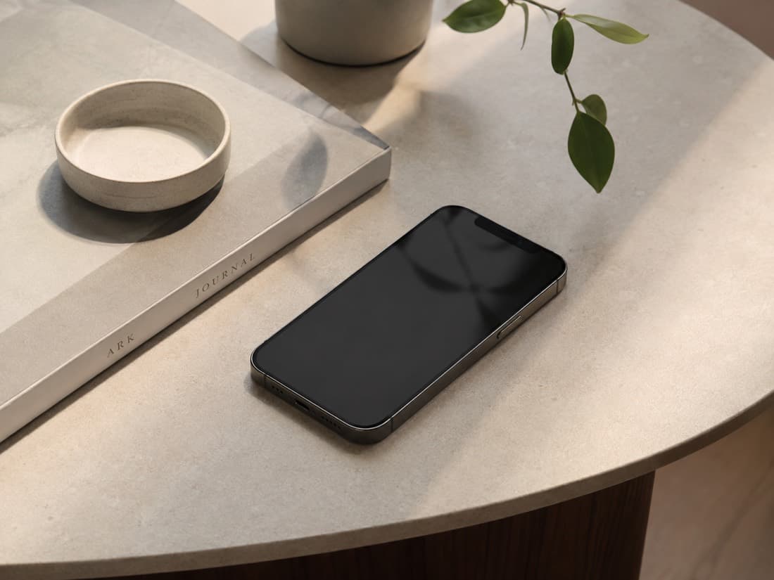 Ein Smartphone mit dunklem Display liegt auf einem Tisch (KI-generiert)